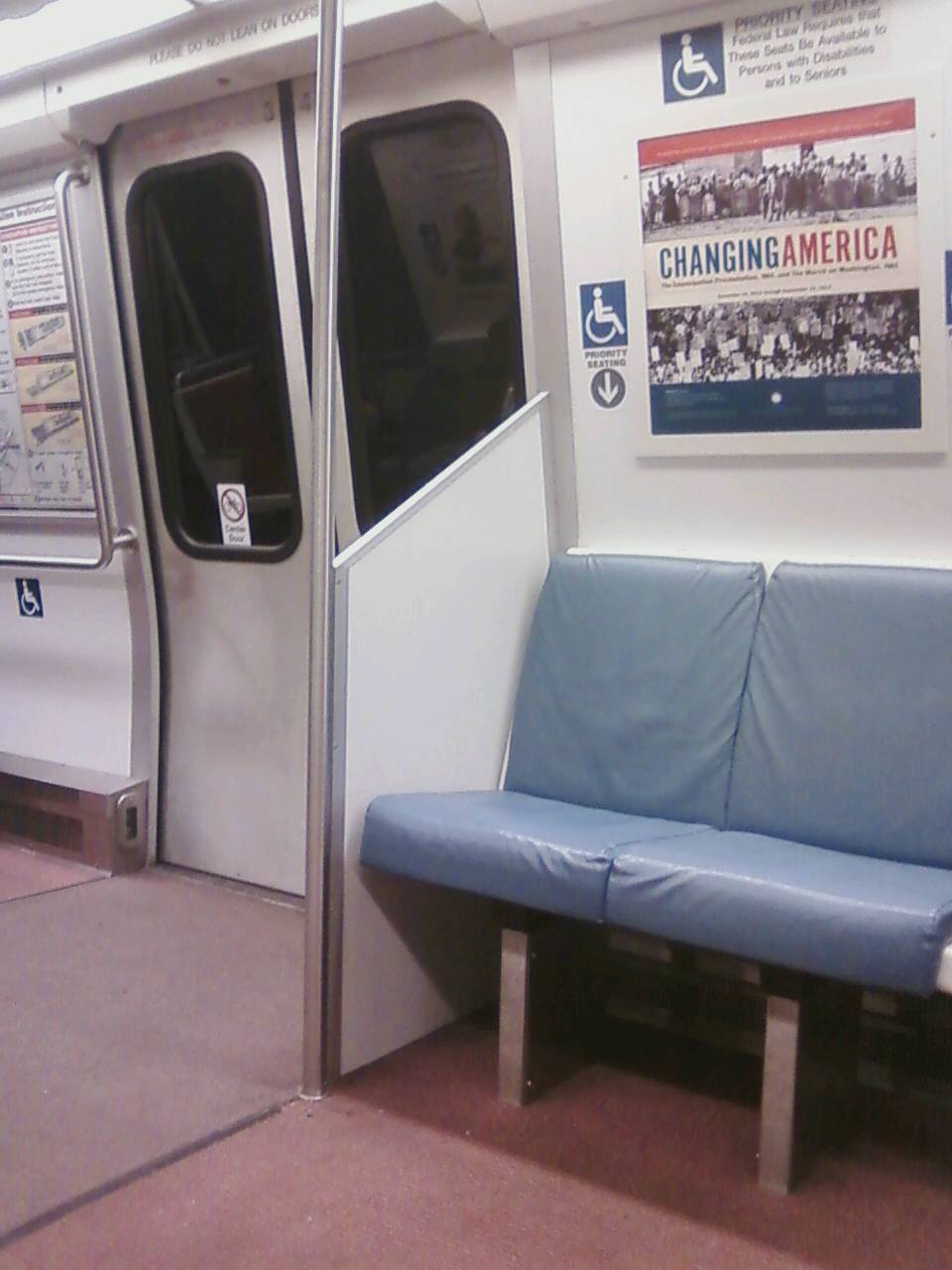 WMATA/DC Metro 6000 series car interior. Note the partition lacks the
top wind screen component. Not only does this partition not shield
passengers from outdoor elements when the train is at an outdoor station,
but passengers seated at the door (in the photos presented) will be
affected by crowding which occurs at the door as there is no effective
partition between standing and exiting/entering passengers and the seated
passengers. For further details, please visit www.wirelessnotes.org.